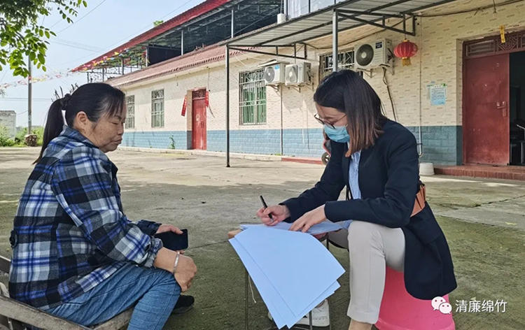 纪委监委干部在群众中了解情况。绵竹市融媒体中心供图