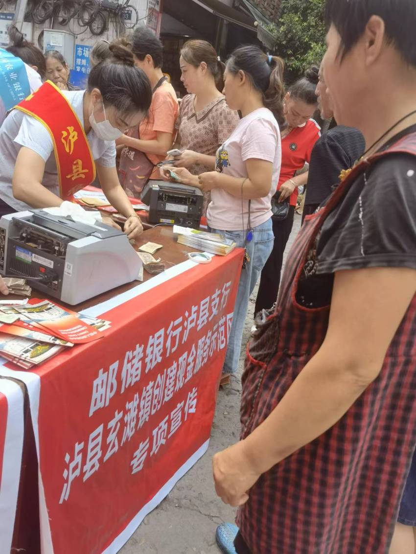 工作人员向居民群众兑换零钞。邮储银行泸县支行供图