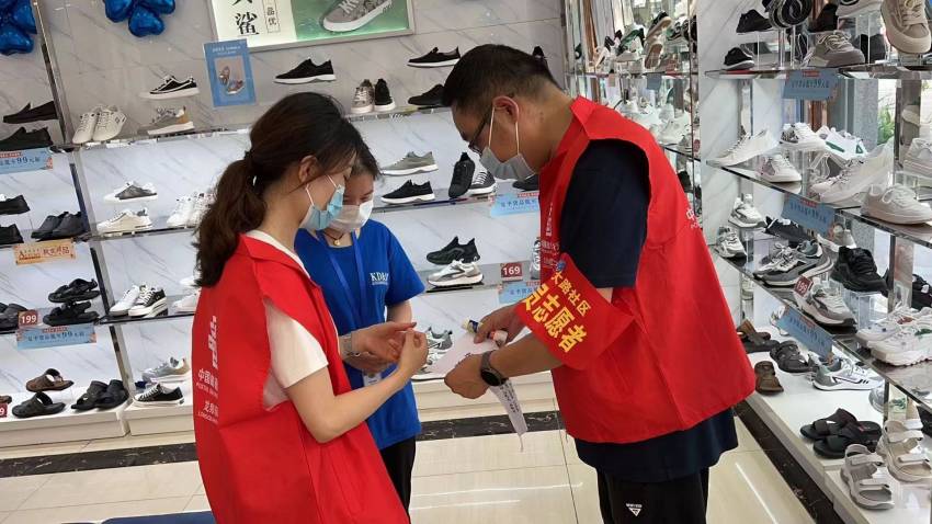志願者協助商家加強疫情防控。郵儲銀行龍泉驛區支行供圖