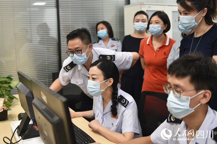 天府新区税务局党委书记、局长万梅和企业代表体验网上办税便捷。胥月摄