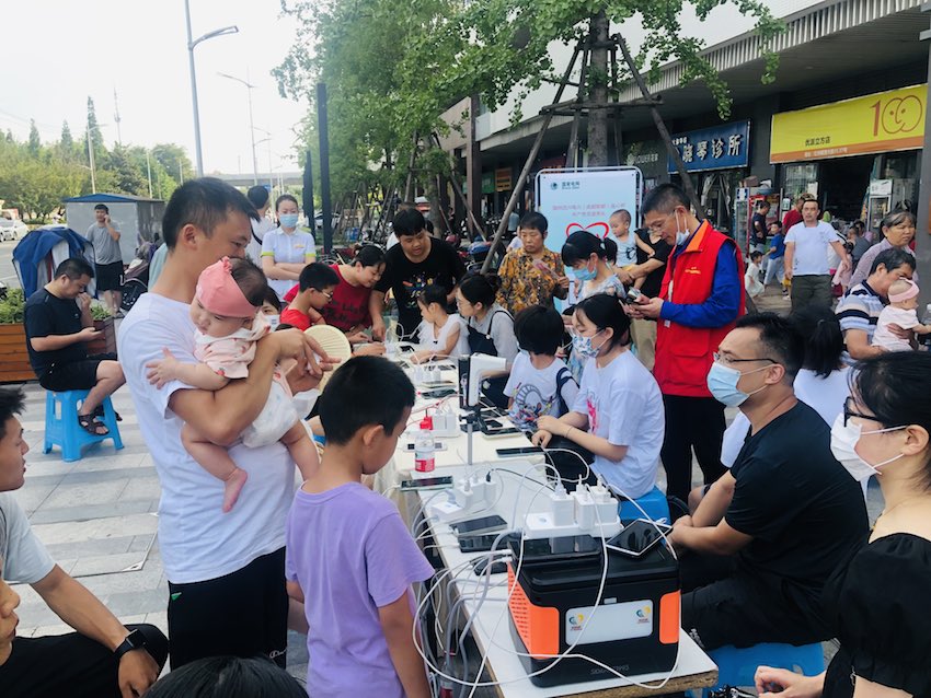 电力抢修服务队在小区门口设立了免费的“手机充电站”。国网郫都公司供图