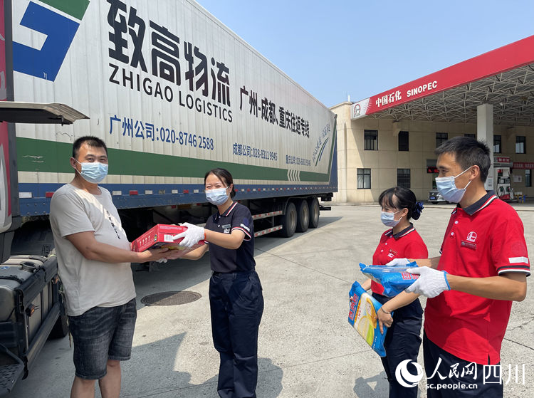 为加油的长途货车司机送上降温饮品。孙艳玲摄