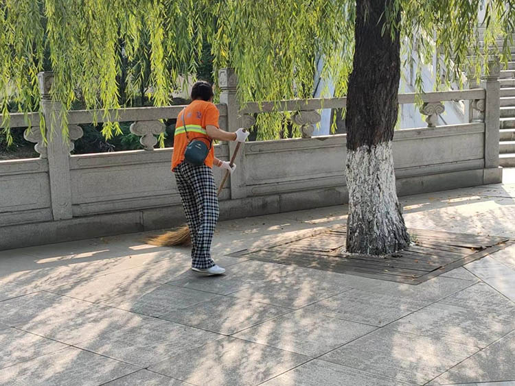 环卫工人清扫树叶垃圾。什邡市融媒体中心供图