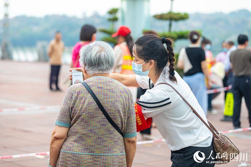 志愿者在帮助老人申领手机健康码。李贵平摄