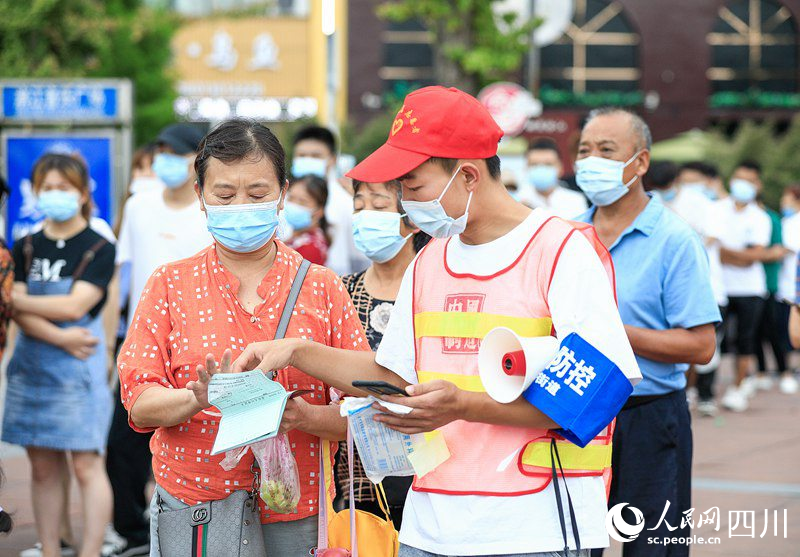 志愿者在帮助老人手工登记个人身份信息。李贵平摄