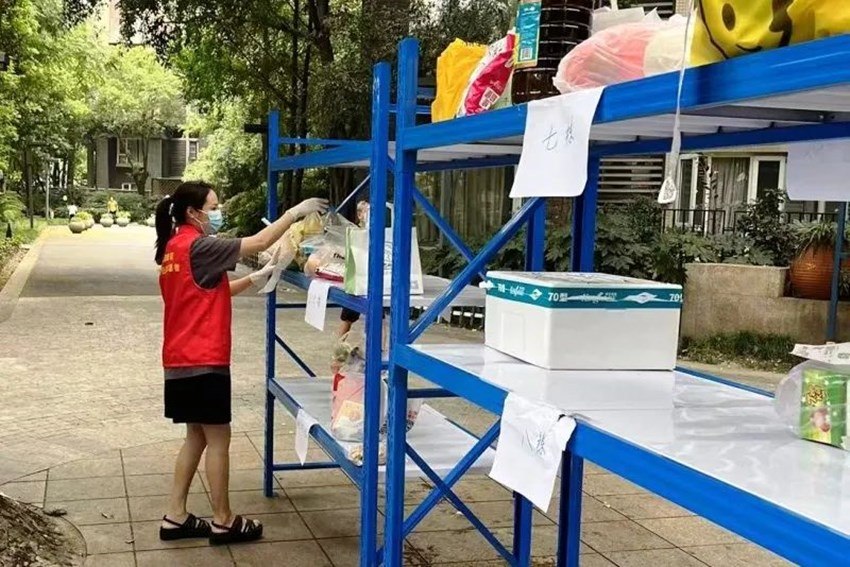 民警幫助居民拿外賣。郫都公安供圖