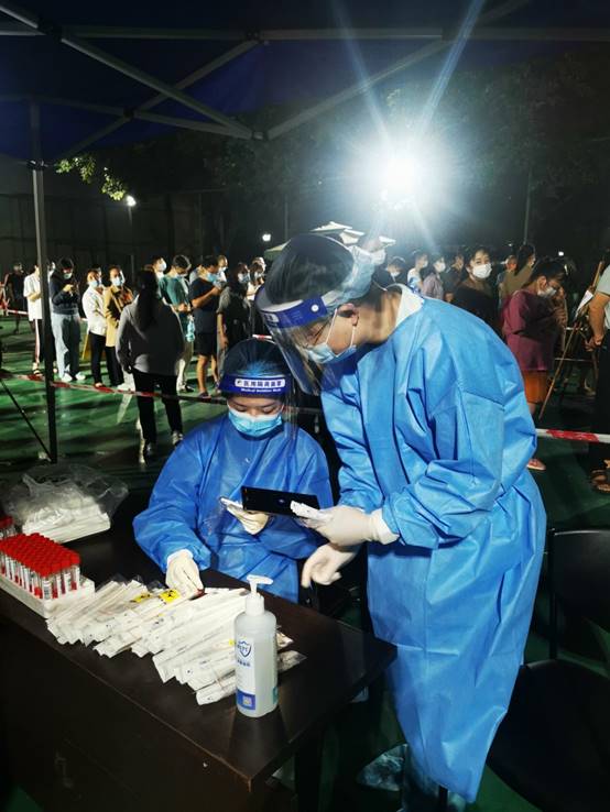 高新税务党员左宇菲与成都银行双流支行党员夏楚鹏组成核酸检测信息采集党员先锋岗。骆芋锟摄