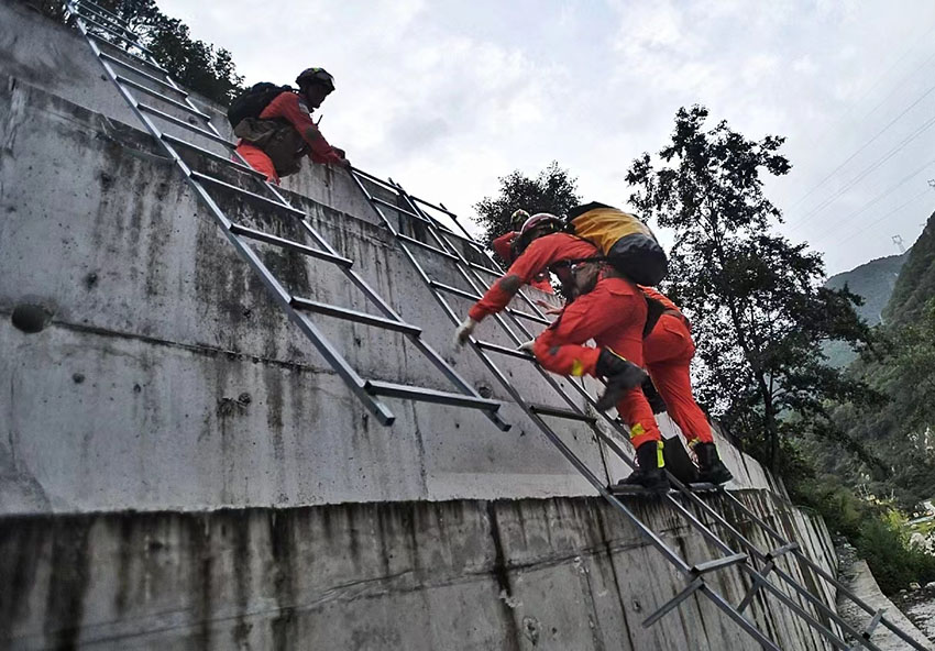 9月5日，消防救援人員因山體滑坡、道路中斷，通過攀爬挺進磨西鎮。四川省消防救援總隊供圖