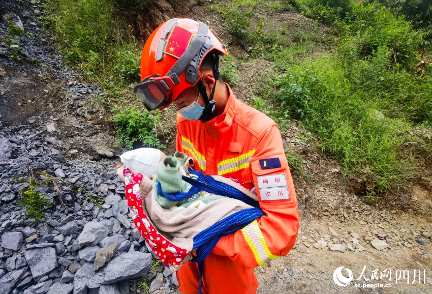 寶寶安靜地躺在森林消防員張自立懷裡。彭科攝