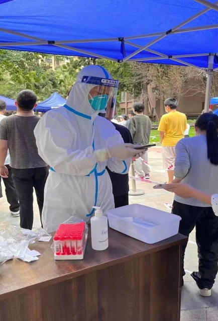 西部文旅公司志愿者协助录入核酸信息，维持现场秩序。四川能投供图