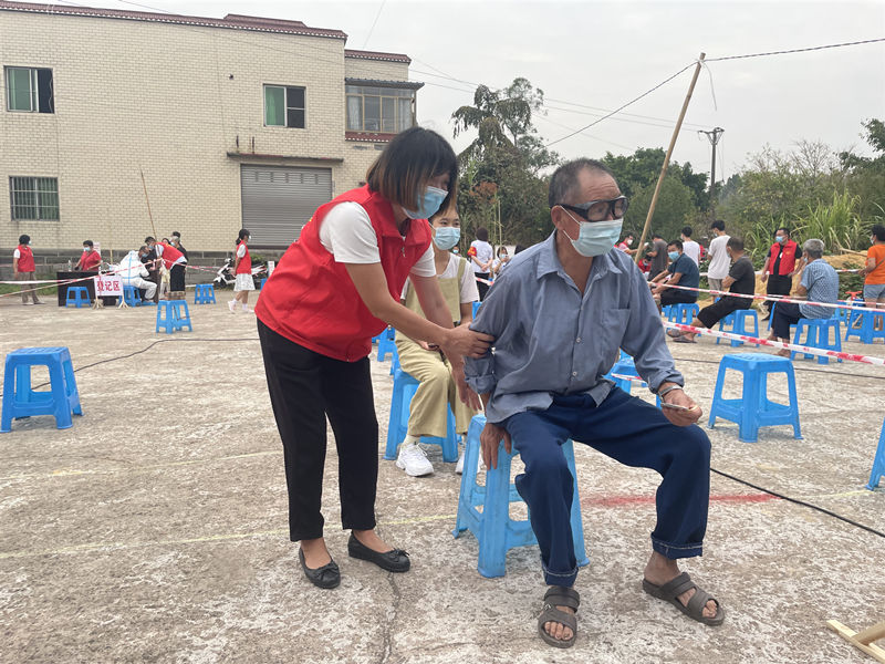 李佳的妈妈搀扶前来进行核酸检测的老人。泸县供图