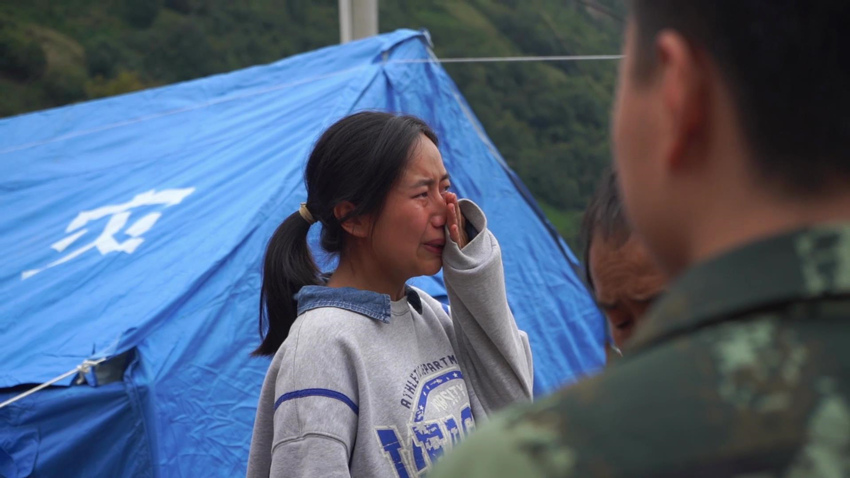 小姑娘用衛星電話報平安后落淚。四川省消防救援總隊供圖