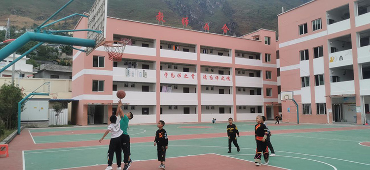 学生们在篮球场上打篮球。雷波县融媒体中心供图