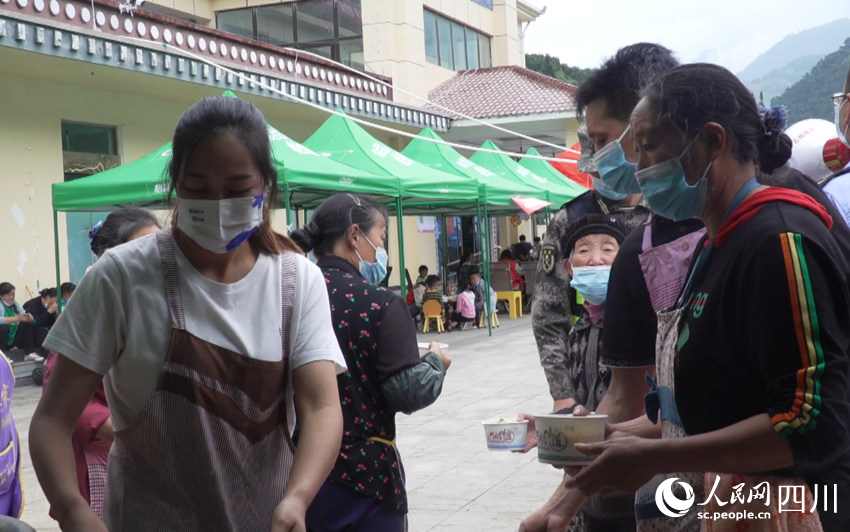 石棉縣王崗坪鄉七裡壩集中安置點內，群眾正在領飯。人民網 王洪江攝