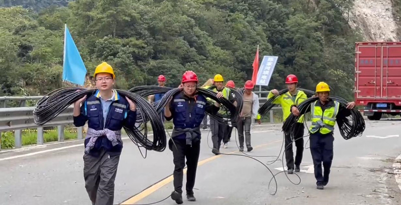 四川移动乐山分公司党员突击队负重徒步前往灾区指定地域。四川省国资委供图