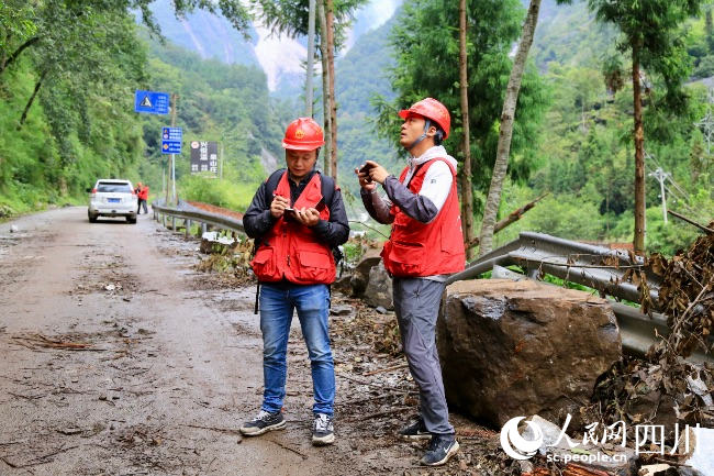 万利宴（左）和同事在现场进行地质灾害隐患排查。人民网 朱虹摄