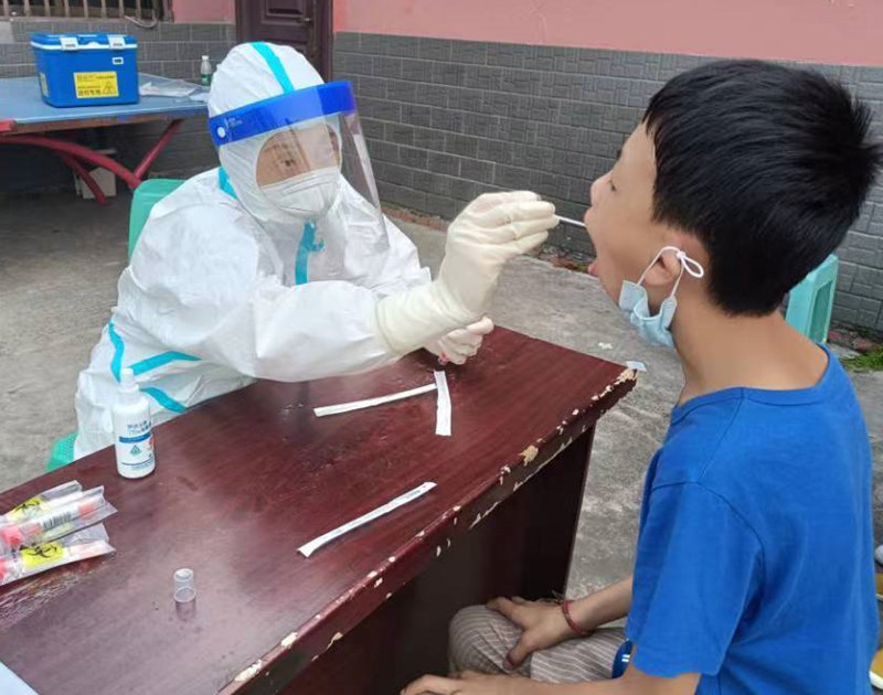 泸县妇幼保健院职工郑朝莲(邓晓波爱人)为群众做核酸检测。泸州市委宣传部供图