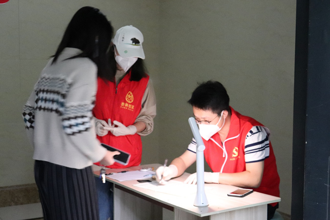 温江区永宁街道杏林社区微网格员刘俊宝做好核酸检测人员登记。温江区委宣传部供图