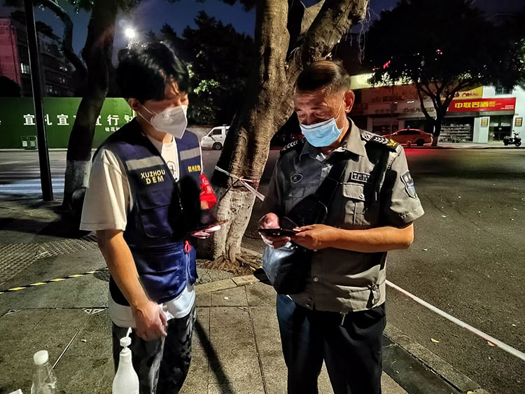 张书伟（左）在卡口检查出入人员核酸检测信息。叙州区融媒体中心供图