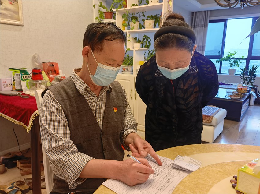王克畅上门登记居民信息，参与防疫志愿活动。李颜摄