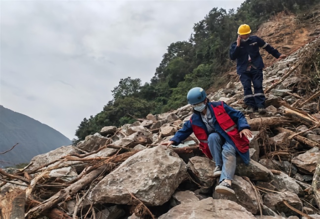 四川省地震局泸定地震现场队员徒步穿越滑坡体前往磨西镇。四川省地震局供图