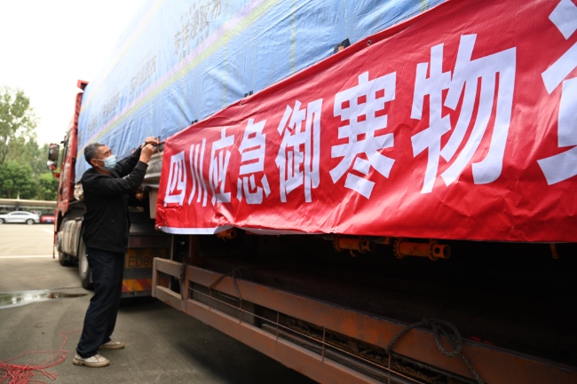 御寒物资的卡车从四川省救灾物资储备中心缓缓驶出。四川省应急管理厅供图