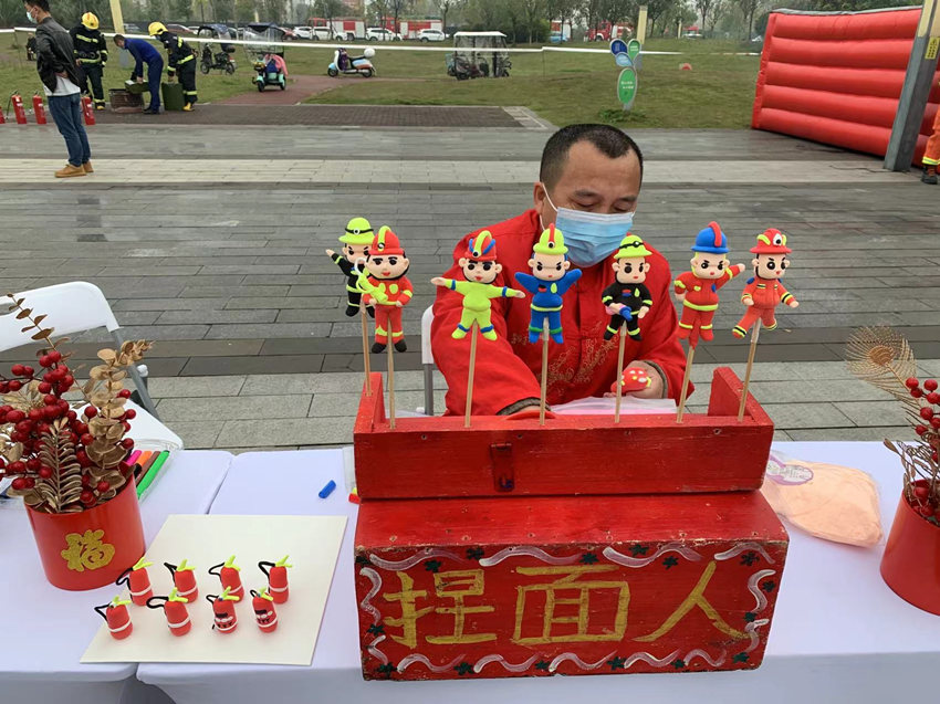 面塑手工藝人在現場制作消防員面人。崇州市消防救援大隊供圖