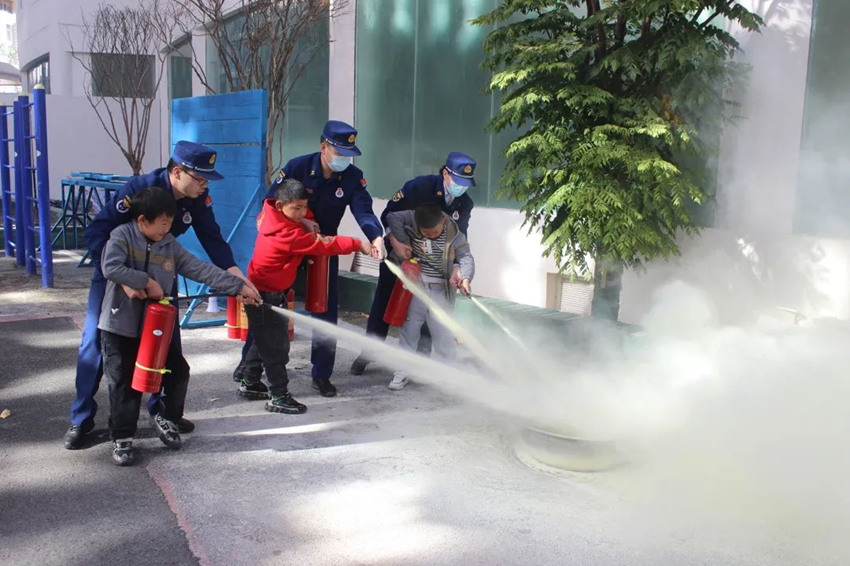 孩子们体验灭火器操作。九寨沟风景名胜区消防救援大队供图