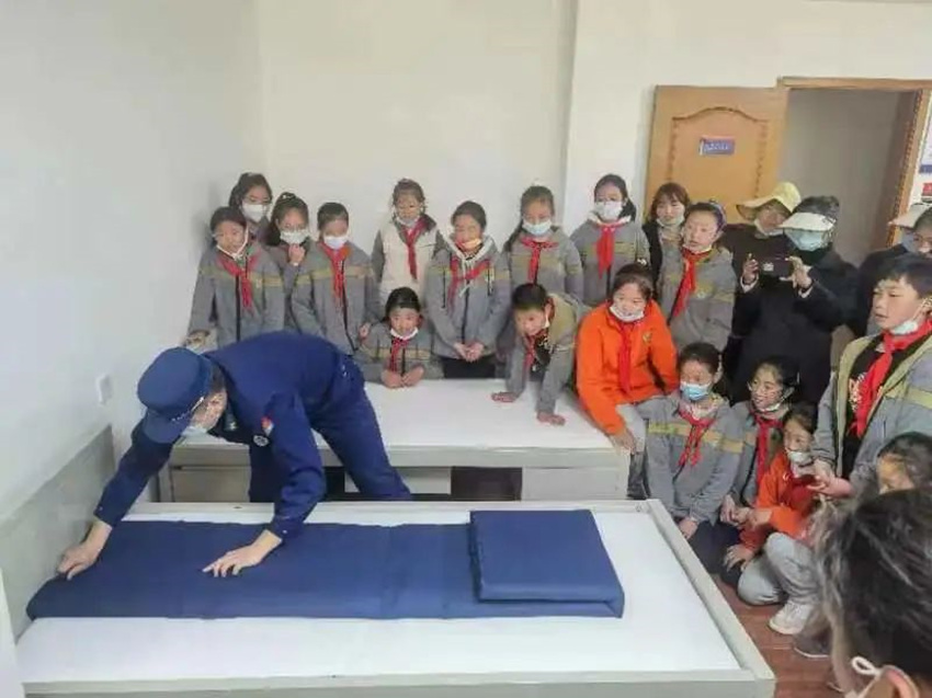 消防员指导孩子们被褥叠放的动作要领。九寨沟风景名胜区消防救援大队供图