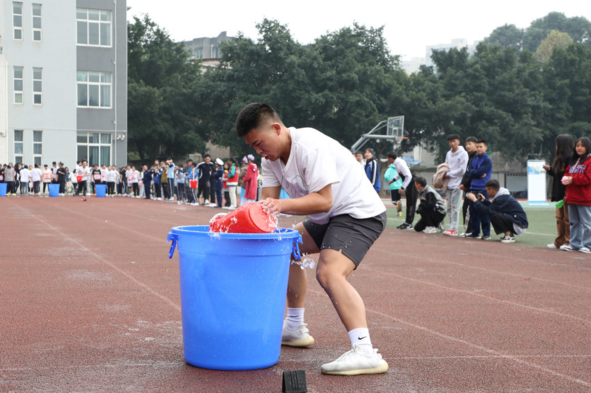 消防運動會上學生們正在進行水桶傳遞穿梭接力賽。樂山市消防救援支隊供圖
