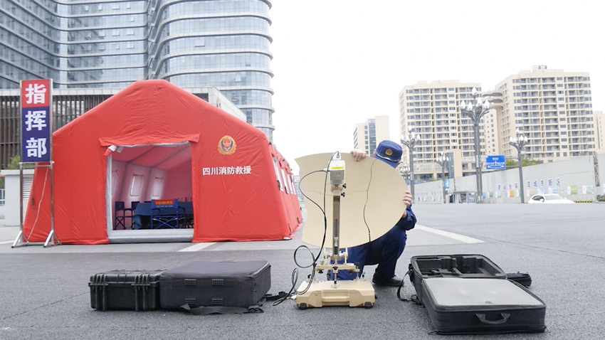 通信员搭建轻型卫星便携站，连通现场卫星网络。四川省消防救援总队供图