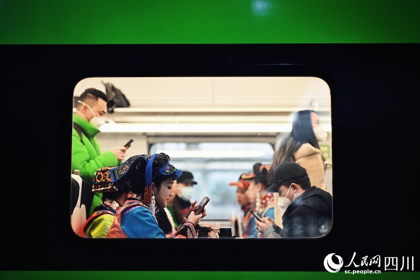 列车内，乘客正在查看自己拍摄的列车图片和视频。李富彬摄