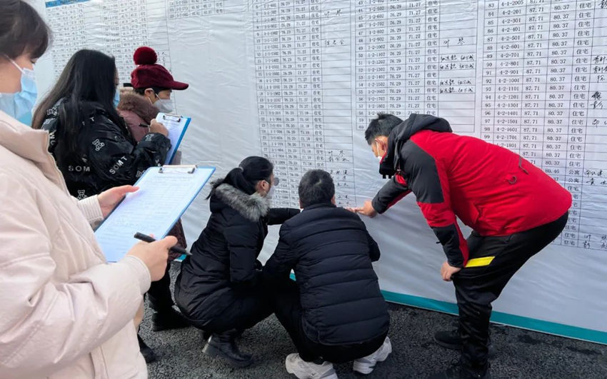 村民在展板上相应位置签名。万安街道供图