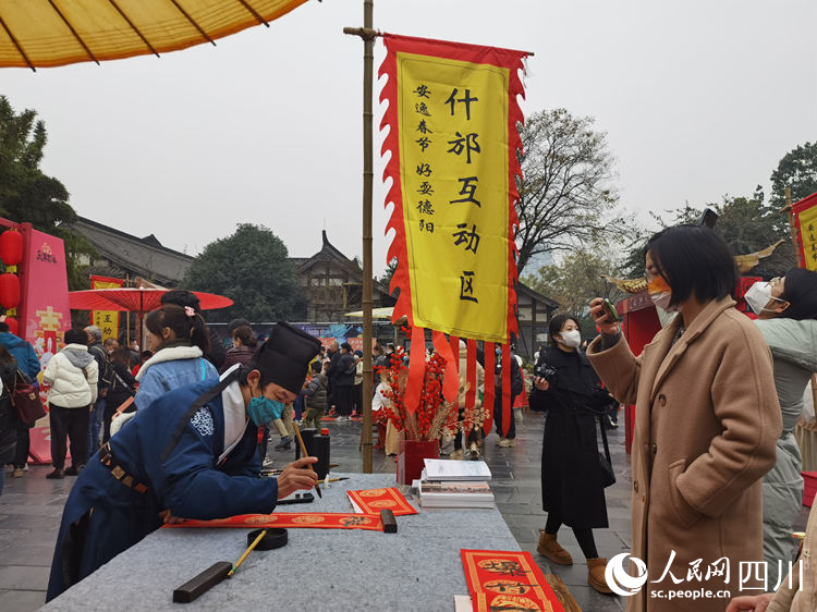 在什邡互动区，为市民写春联。人民网 王波摄