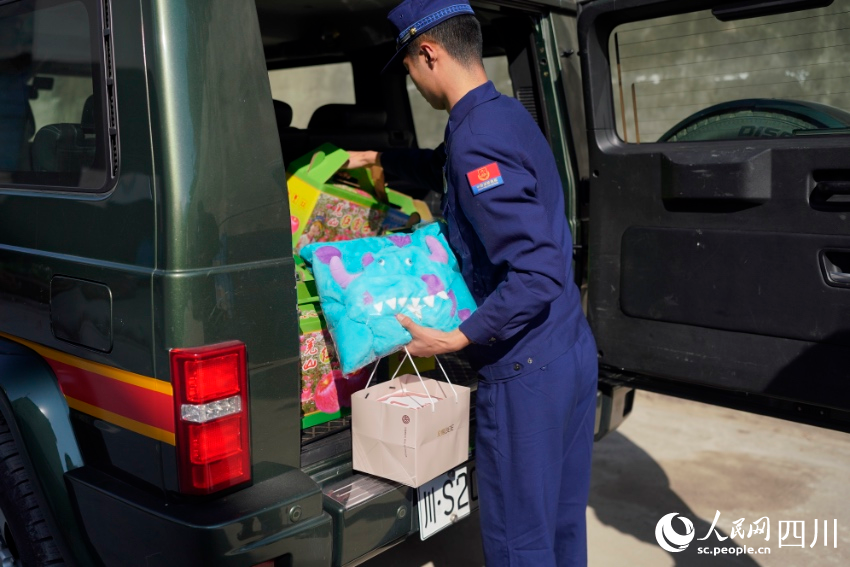 張自立從車上取下送給楊澤楷的禮物。彭科攝