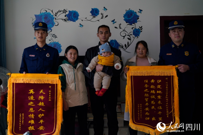 張自立（左一）和一家人合影留念，楊得義送上早就做好還沒來得及送的錦旗。彭科攝