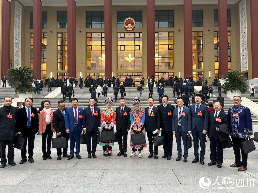 1月11日，四川省十四屆人大一次會議在成都召開，代表們在會場前合影留念。人民網 王波攝