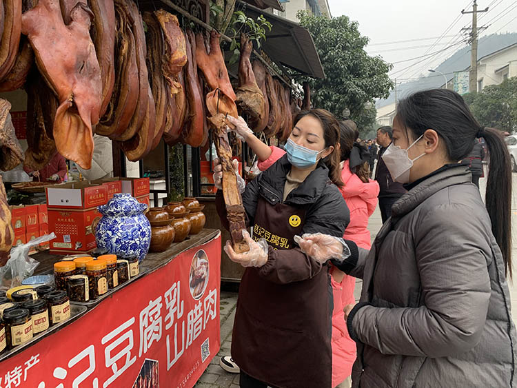 市民选购腊肉香肠。刘姮摄