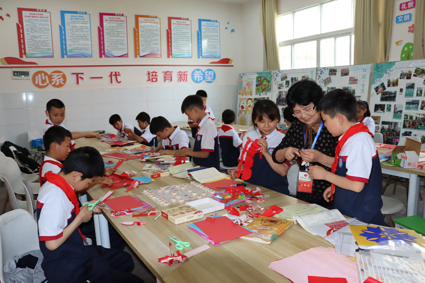 五老志愿者走进周末假日寄宿学校开展兴趣关爱活动，培训剪纸艺术。宣汉县委宣传部供图