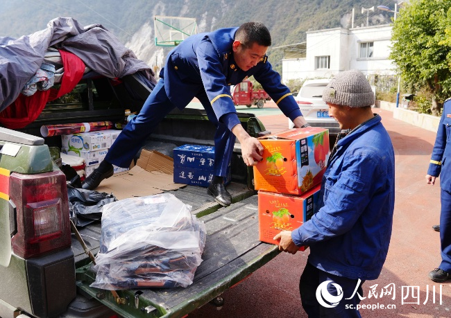 1月17日，在雅安市石棉縣王崗坪彝族藏族鄉愛國村，消防救援人員為群眾送去慰問品。李從林攝
