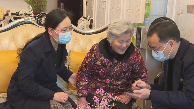 社保工作人员帮熊大珍完成人脸认证。叙州区融媒体中心供图