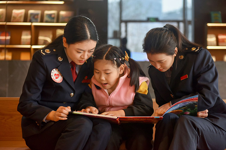 “税务妈妈”陪伴小女孩阅读。天府新区税务局供图