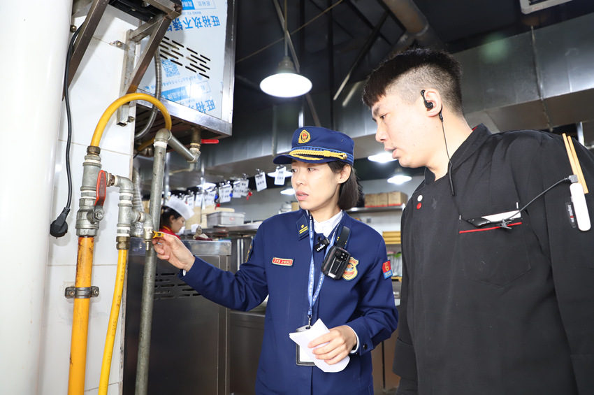 消防监督员走进商业综合体后厨，排查燃气消防安全隐患。南充市消防救援支队供图