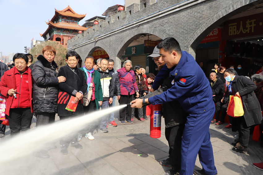 指导群众如何正确使用灭火器。遂宁市消防救援支队供图
