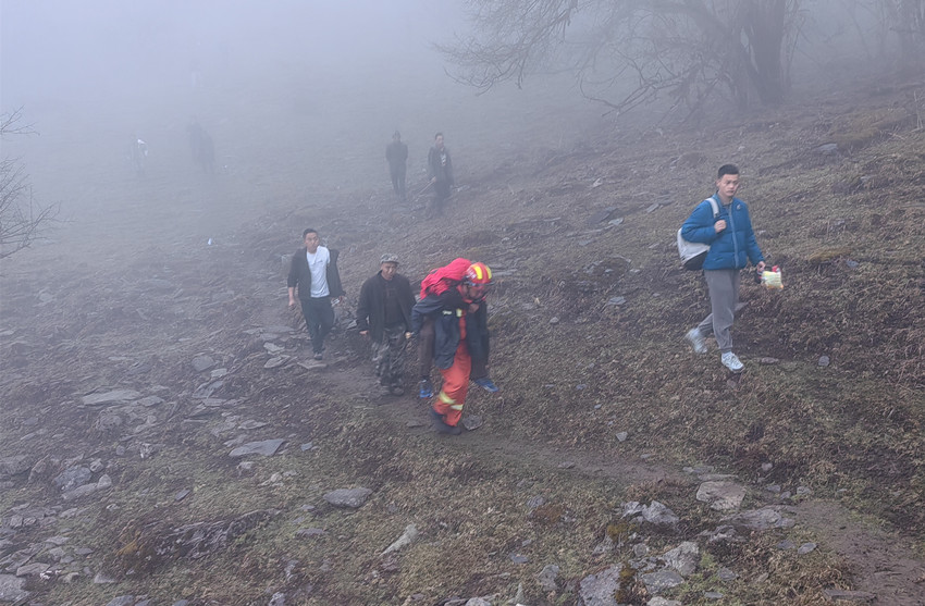 消防救援人員正在運送受傷游客下山。阿壩州消防救援支隊供圖