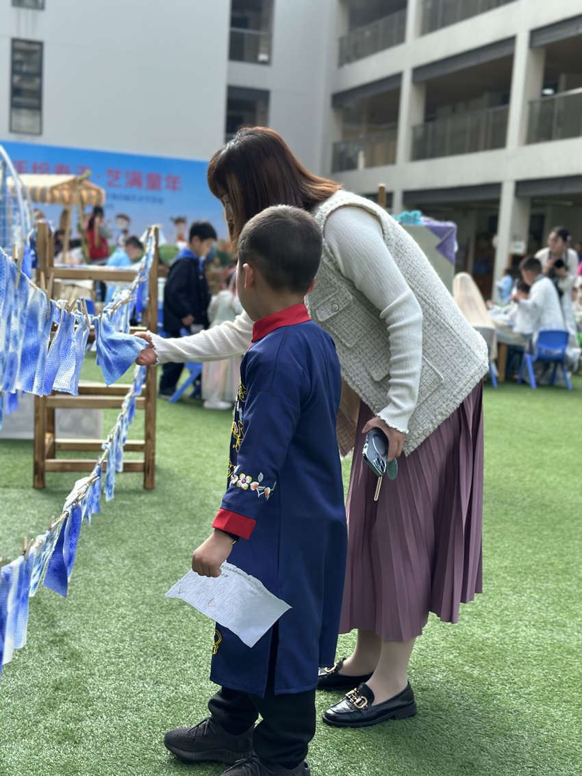 老师与孩子正在看扎染作品。成都市第三幼儿园528园区供图