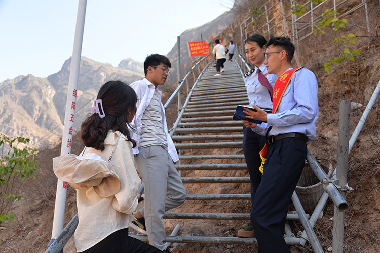 税务干部在悬崖村旅游景点向过往游客宣传税收政策。凉山州税务局供图