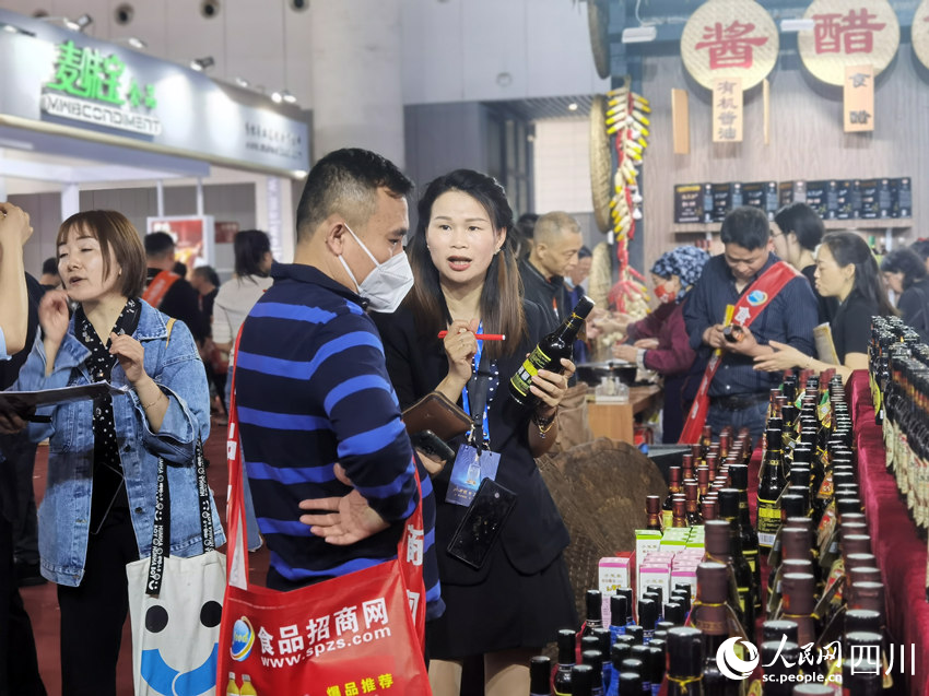 参展商正在向客户推介产品。人民网 王洪江摄