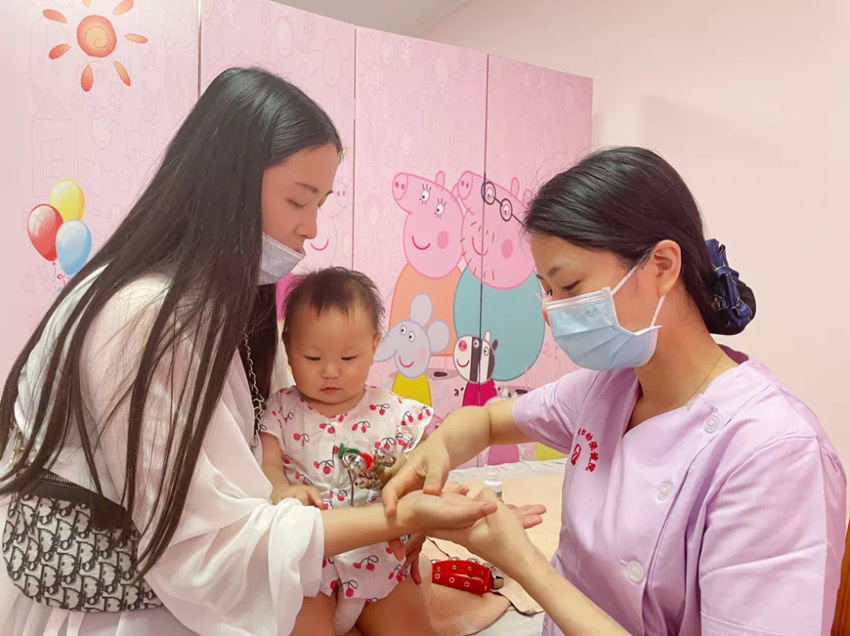 护士教授家长推拿方法。绵竹市妇幼保健计划生育服务中心供图