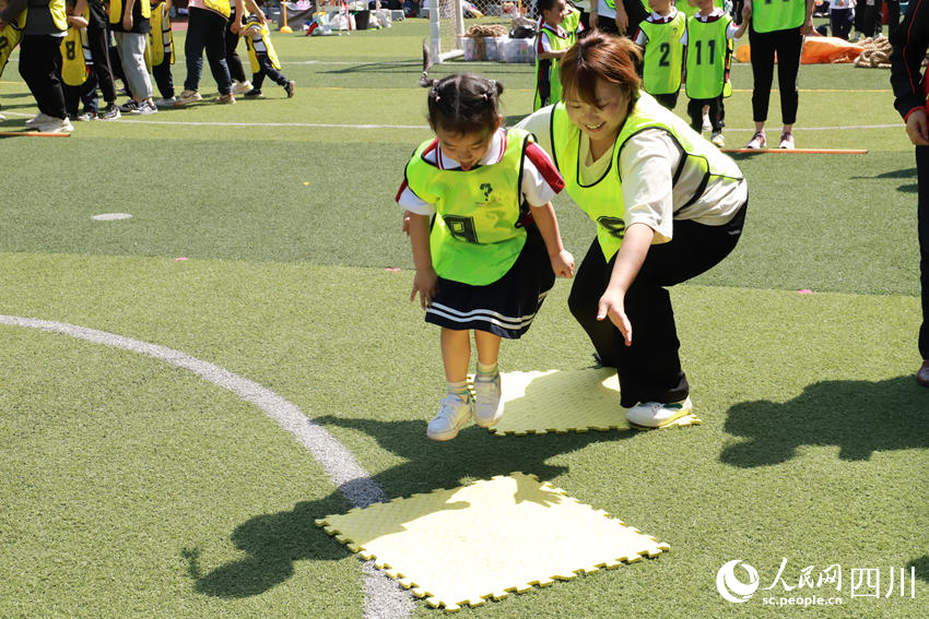 亲子“踏石过河”比赛，家长孩子齐欢乐。李恭玉摄